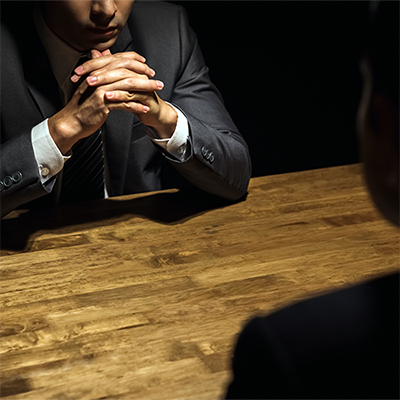 Person in shadow conducting a counter-terrorism interview.